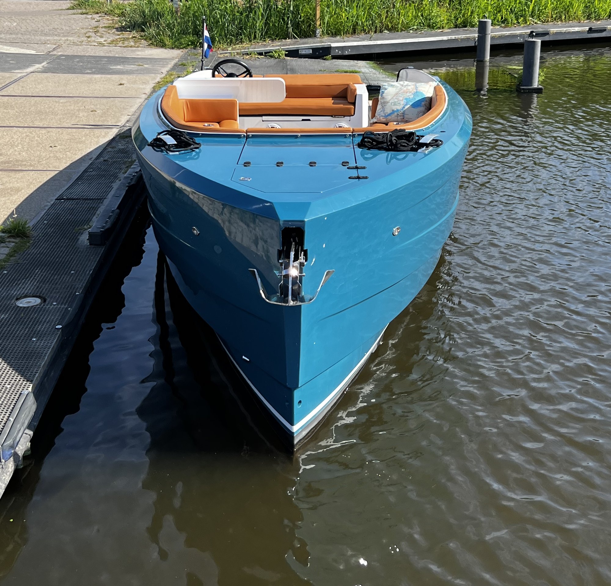 Boeg van de Sognare Amalfi 760 in glanzend blauw aluminium aan de steiger